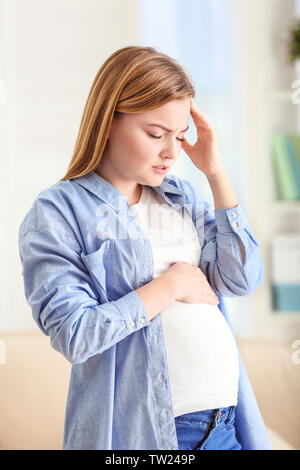 Schwangere Frau leidet unter Kopfschmerzen zu Hause Stockfoto