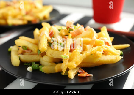 Teil der Leckere Pommes Frites mit Speck und Zwiebel, Nahaufnahme Stockfoto