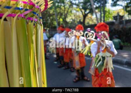 DENPASAR/BALI - 15. JUNI 2019: Junge balinesischer Junge tragen traditionelle balinesische Kopfschmuck und traditionellen Sarong sampian bringen bei der Eröffnung der Stockfoto