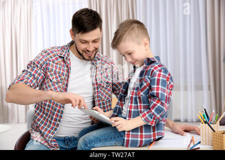Vater und Sohn mit Tablet Computer zu Hause. Stockfoto