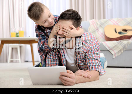 Vater und Sohn mit Tablet Computer zu Hause. Stockfoto