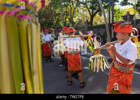 DENPASAR/BALI - 15. JUNI 2019: Junge balinesischer Junge tragen traditionelle balinesische Kopfschmuck und traditionellen Sarong sampian bringen bei der Eröffnung der Stockfoto