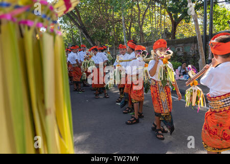 DENPASAR/BALI - 15. JUNI 2019: Junge balinesischer Junge tragen traditionelle balinesische Kopfschmuck und traditionellen Sarong sampian bringen bei der Eröffnung der Stockfoto