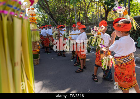 DENPASAR/BALI - 15. JUNI 2019: Junge balinesischer Junge tragen traditionelle balinesische Kopfschmuck und traditionellen Sarong sampian bringen bei der Eröffnung der Stockfoto