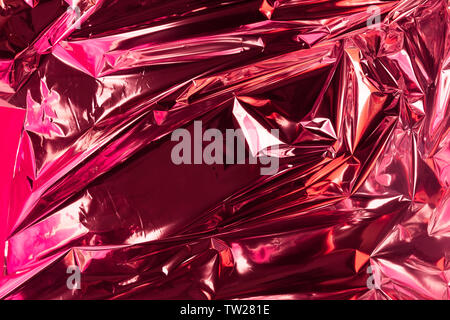 Abstrakte zerknitterte Folie Hintergrund. Grunge foto Hintergrund. Neon Farben. Rot und rosa Farben. Stockfoto