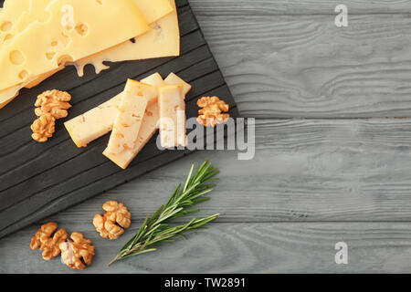 Zusammensetzung der geschnittenen Käse und Nussbaum auf dem Schwarzen Brett Stockfoto