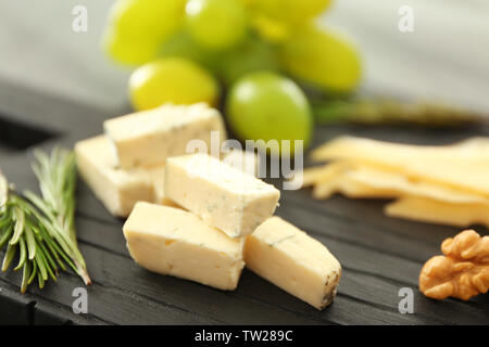 Zusammensetzung der geschnittenen Käse und Nussbaum auf dem Schwarzen Brett Stockfoto