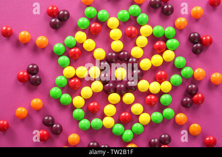 Bunte Bonbons in Form von Stern auf farbigen Hintergrund Stockfoto