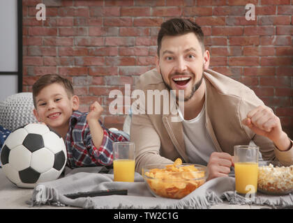 Vater und Sohn, Fußball im Fernsehen zu Hause Stockfoto