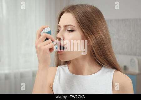 Junge Frau mit Asthma Inhalator zu Hause Stockfoto