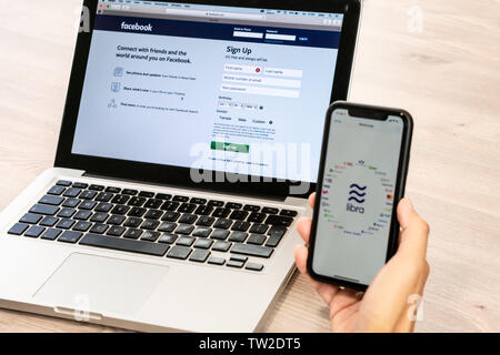 18. Juni 2019, Ljubljana, Slowenien - Hand mit einem Smartphone mit Waage Logo und der Waage Partner, neben Facebook Website eröffnet am Laptop Stockfoto