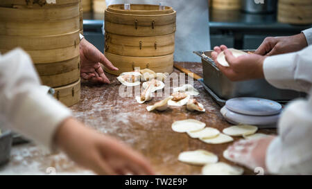 Taiwanesische Team von Köchen kochen traditionelle Speisen. Asiatische Koch frische Knödel im Restaurant von Taiwan. Männer Hände kochen und prepairing Teig Stockfoto