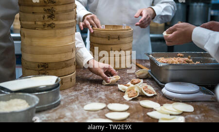 Taiwanesische Team von Köchen kochen traditionelle Speisen. Asiatische Koch frische Knödel im Restaurant von Taiwan. Männer Hände kochen und prepairing Teig Stockfoto