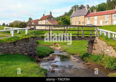 Holzbrücke über Hutton Beck im Dorf Hutton-le-Hole am Rande der North York Moors, Yorkshire, England, Großbritannien Stockfoto