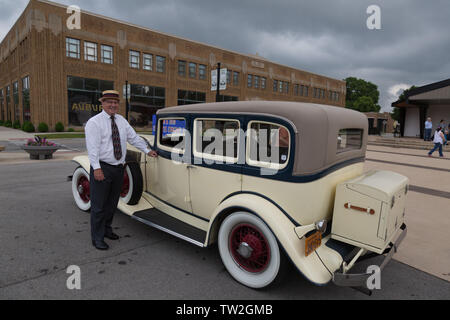 Ein Mann steht neben seiner gelben 1931 Auburn 8-98 Limousine gegenüber dem Auburn Cord Duesenberg Museum in Auburn, Indiana, USA. Stockfoto