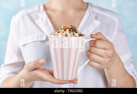 Frau mit Tasse Kakao trinken mit Sahne in den Händen Stockfoto