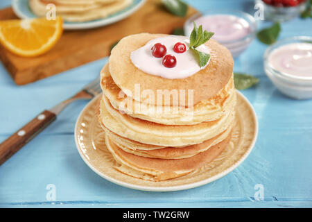 Mit leckeren Pfannkuchen, Joghurt und Cranberry auf Blau Tischplatte Stockfoto