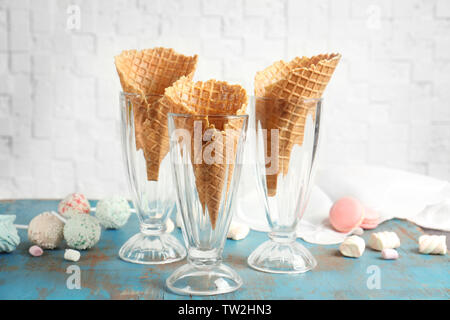 Leckere Waffeln für Speiseeis in Gläsern auf dem Tisch Stockfoto