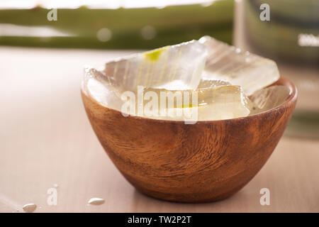 Schüssel mit geschälten Aloe vera und grüne Blätter auf hölzernen Hintergrund Stockfoto