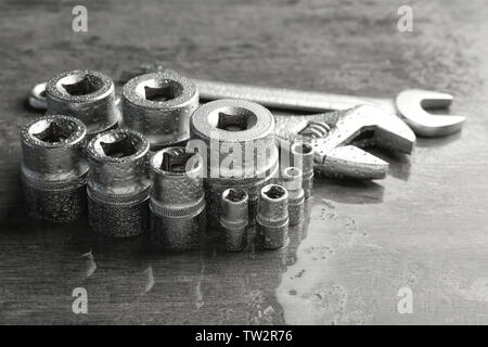 Hand sockets, Schraubenschlüssel und Schraubenschlüssel auf nassen Tabelle Stockfoto