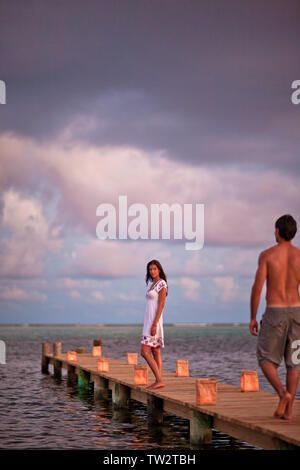 Junge Frau ihr Partner auf dem Weg zu ihr auf ein Abendessen bei Kerzenschein Pier. Stockfoto
