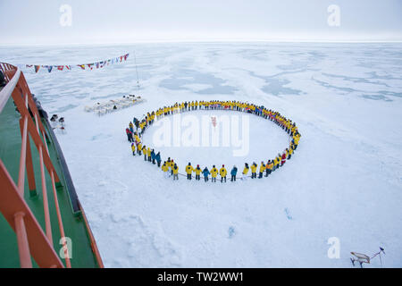 Touristen form Kreis am Nordpol nach Erreichen von 90 Grad Nord auf russischen Eisbrecher 50 Jahre Sieg. Juli 2008. Stockfoto