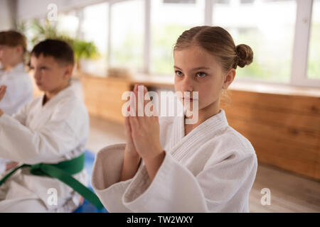 Die Namaste anmelden. Attraktive blonde Mädchen lernen Aikido machen Namaste anmelden Stockfoto