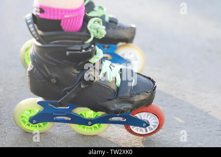 Roller skater bereit zum Start. Real arbeitenden zerschlagene Rollen für Inline- und Slalom skaten. Schwarze Schuhe blau auf drei Rädern Rahmen mit bunten Rad Stockfoto