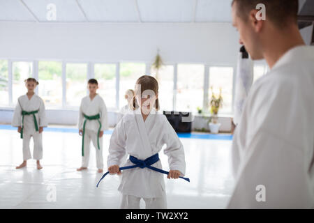 Schwere Mädchen. Süße kleine Mädchen tragen weiße Aikido in ernsten Gesicht vor dem Üben Aikido Stockfoto