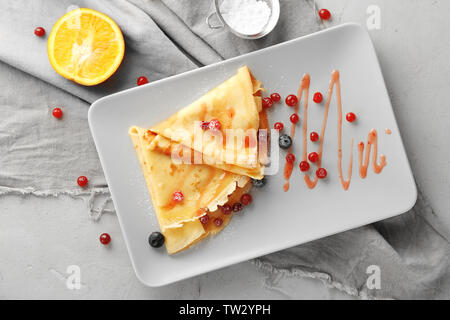 Leckere Pfannkuchen mit Beeren Soße für Frühstück auf Platte Stockfoto