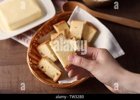 Detailansicht der Frau mit Butter Kuchen Stück über Tabelle Stockfoto