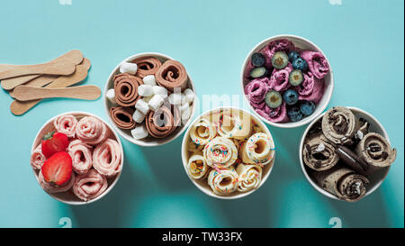 Gerollt Eis cone Cups auf blauem Hintergrund. Verschiedene iced Brötchen Top View oder flach. Im thailändischen Stil gerollt Ice Cream Stockfoto