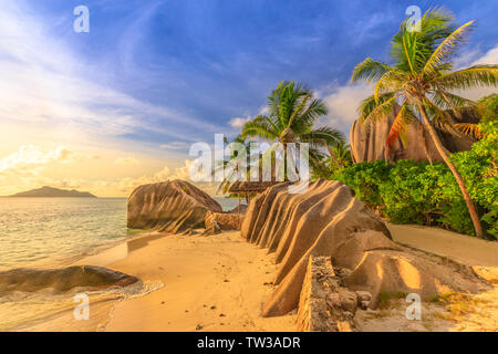 Anse Source D'Argent bei Sonnenuntergang. Seychellen, La Digue. Landschaft mit Palmen und Stein aus Granit blouders. Sonnenlicht über dem Horizont. Quelle d Stockfoto
