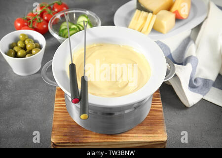 Fondue-set, Käse und Gemüse auf Tisch Stockfoto