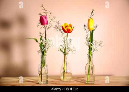Vasen mit schöner Frühling Blumen auf hölzernen Tisch Stockfoto