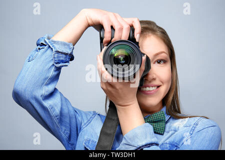 Schöne junge Fotografen auf hellen Hintergrund Stockfoto