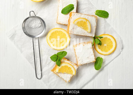 Leckere Lemon Pie bars und Sieb mit Puderzucker auf hölzernen Tisch Stockfoto