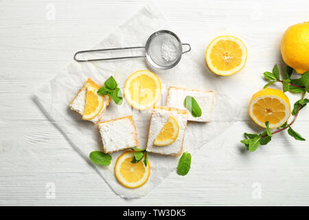 Leckere Lemon Pie bars und Sieb mit Puderzucker auf hölzernen Tisch Stockfoto