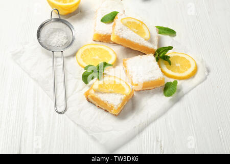 Leckere Lemon Pie bars und Sieb mit Puderzucker auf hölzernen Tisch Stockfoto