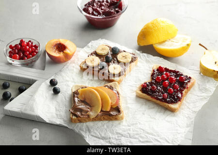 Verschiedene leckere Frühstück Toast mit Früchten und Beeren auf Tisch Stockfoto