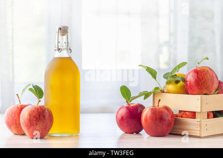 Gesunde Bio-lebensmittel. Apfelessig in Glas und Flasche frische rote Äpfel auf einem hellen Hintergrund. Stockfoto