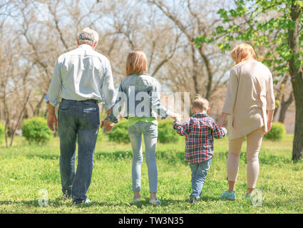 Glückliche Kinder mit Großeltern wandern in Spring Park an einem sonnigen Tag Stockfoto