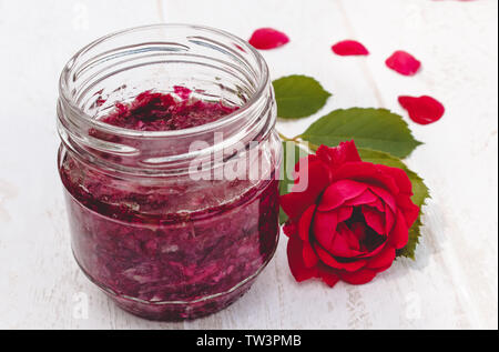 Stau von Rosenblüten im Glas auf einem hellen Hintergrund. Blume Konfitüre. Gesundes Essen. Platz kopieren Stockfoto