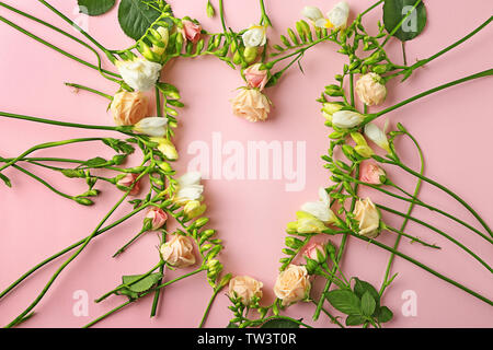 Zusammensetzung der wunderschönen Rosen und Freesien Blumen auf rosa Hintergrund Stockfoto