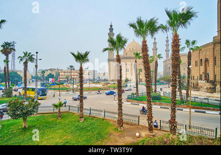 Kairo, Ägypten - Dezember 21, 2017: Blick auf den geschäftigen Salah El-Deen Platz mit Sultan Hassan und Al-Rifa' ich Moscheen durch die Palmen, am 2. Dezember Stockfoto