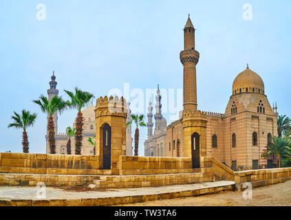 Der Blick auf die steinerne Wachtürme von Bab Al-Azab Tor der Zitadelle von Saladin und die hohen Minarette von großen historischen Moscheen von Sultan Hassan, Al-Rifa'i, Stockfoto