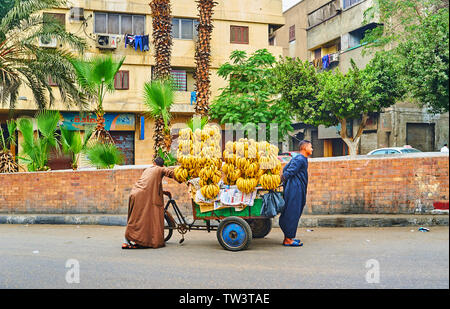 Kairo, Ägypten, 22. Dezember 2017: Die Anbieter ziehen Sie die alte Karre, voller frische Bananen, entlang des Saladin Square im Lebensmittelmarkt, am 22. Dezember in Stockfoto