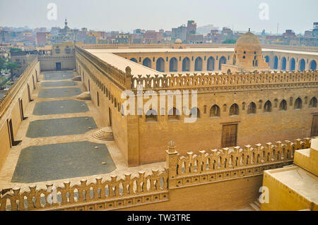 Die inneren und äußeren Mauern der mittelalterlichen Ibn Tulun Moschee, verziert mit geschnitzten Zinnen und Bogenfenstern; die Kuppel der Waschung Brunnen gesehen bin Stockfoto