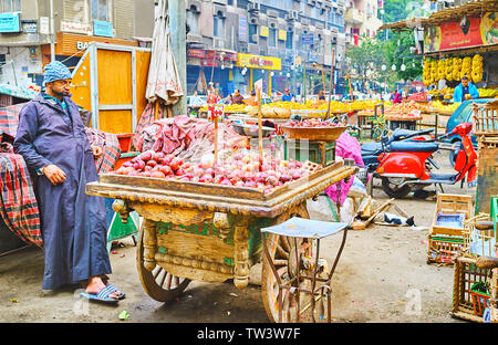 Kairo, Ägypten - Dezember 22, 2017: Der Anbieter an seinem Vintage wooden cart, voll von roten Zwiebeln in der Straße von Souq als Sebaeyin Basar, der am 22. Dezember in Stockfoto