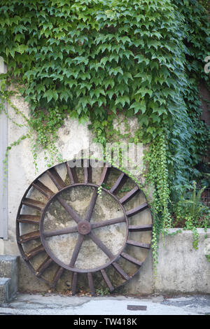 Die alte Wassermühle Rad am Efeu bedeckten Wand Stockfoto